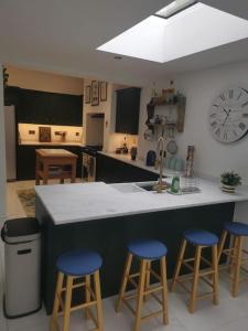 a kitchen with a counter and three blue bar stools at Prime location for Snowdon, Family and Dog friendly! in Llanberis