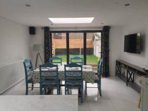 a dining room with a table and chairs and a television at Prime location for Snowdon, Family and Dog friendly! in Llanberis