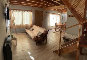 uma sala de estar com um sofá e uma mesa em Hermosa y confortable casita en Bariloche em San Carlos de Bariloche