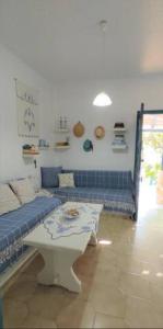 a living room with a couch and a table at A Cretan house in a garden,overlooking the sea. in Ierapetra