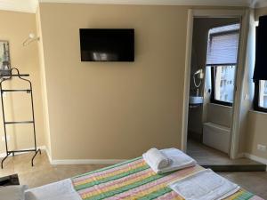 een slaapkamer met een bed en een televisie aan de muur bij Casual Stay Galileo in Reggio di Calabria