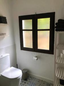 a bathroom with a toilet and two windows at Casita Azahar Andalucia in Alhaurín de la Torre +33 photos