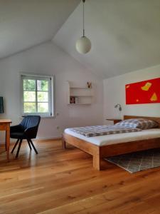 Schlafzimmer mit einem Bett, einem Schreibtisch und einem Stuhl in der Unterkunft Idyllisches Schwedenhaus in ruhiger Hanglage in Oetzen