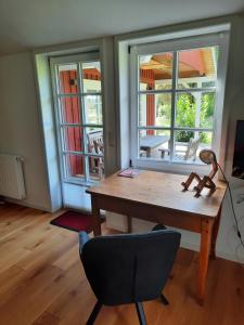 einen Tisch und einen Stuhl in einem Zimmer mit Fenstern in der Unterkunft Idyllisches Schwedenhaus in ruhiger Hanglage in Oetzen