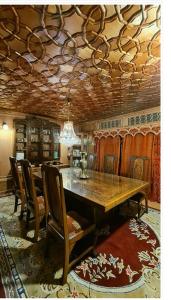 uma sala de jantar com uma mesa de madeira e cadeiras em Lala Rukh Group Of Houseboats em Srinagar