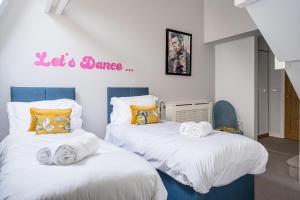 two beds with towels on them in a bedroom at Kensington Heights in Bath