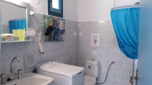 a bathroom with a toilet and a sink and a mirror at A Cretan house in a garden,overlooking the sea. in Ierapetra