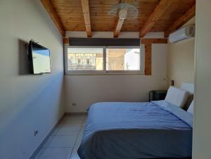 a bedroom with a blue bed and a window at Cuttigghiu Holiday Apartment in Catania