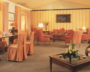 pokój hotelowy z pomarańczowymi krzesłami i poczekalnią w obiekcie Balletti Palace Hotel w mieście Viterbo