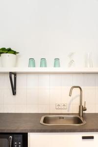 a kitchen sink with a shelf above it at Hip & Minimalist meets Historical Old Town in Pirna