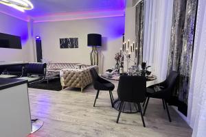 uma sala de estar com iluminação roxa e uma mesa e cadeiras em Appartement de luxe avec Jacuzzi au centre de Metz em Metz