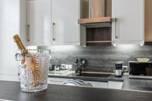 a bottle of champagne in a vase on a kitchen counter at Appartement de luxe avec Jacuzzi au centre de Metz in Metz