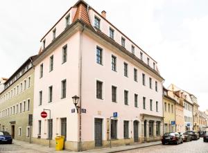 een wit gebouw op een straat met geparkeerde auto's bij Hip & Minimalist meets Historical Old Town in Pirna