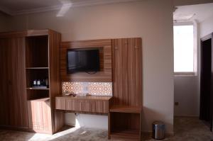 a entertainment center with a television on a wall at Artal Taiba Hotel in Al Madinah +33 photos