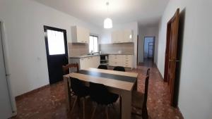 een keuken met een tafel en stoelen in een kamer bij Casa Rural Doña Catalina in Jimena de la Frontera