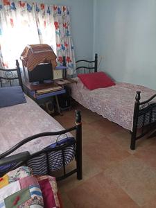 a room with three beds and a television in it at Issa's House in Bayt Sāḩūr
