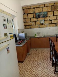 a kitchen with a refrigerator and a brick wall at Issa's House in Bayt Sāḩūr