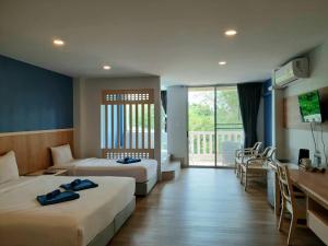a hotel room with two beds and a balcony at Karon Living Room - SHA Plus in Karon Beach