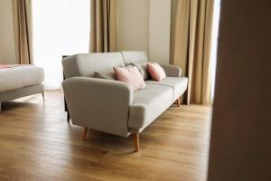 a living room with a couch with two pink pillows at FAY Victoria Beach in Rincón de la Victoria