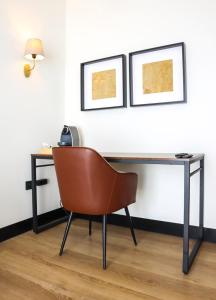 a desk with a chair and two pictures on the wall at FAY Victoria Beach in Rincón de la Victoria