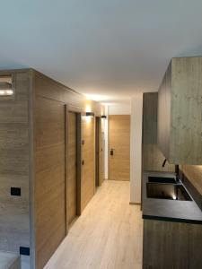 a kitchen with wooden walls and a hallway with wooden floors at Des Alpes C Flat 11 in Madonna di Campiglio