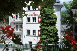 Un edificio bianco con un albero di Natale davanti di Hotel Gisela a Bad Gastein