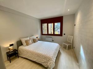 a white bedroom with a bed and a window at Prober Comapedrosa in Arinsal