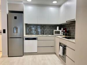 a kitchen with white cabinets and a refrigerator at Prober Comapedrosa in Arinsal