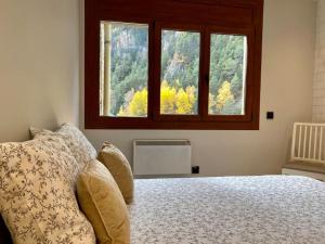 a bedroom with a large bed with a window at Prober Comapedrosa in Arinsal