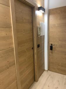 a wooden door in a room with a wall at Des Alpes C Flat 11 in Madonna di Campiglio