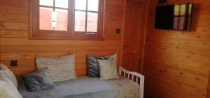 een kamer met een bed met kussens en een televisie bij Ferme Sacrée Nature in Ben Slimane