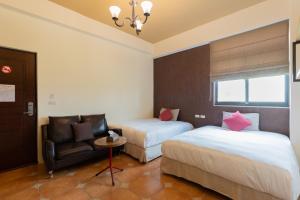 ein Hotelzimmer mit 2 Betten und einem Stuhl in der Unterkunft 時光輕旅 Time INN in Altstadt von Hengchun