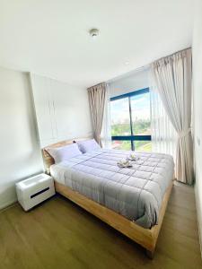 una camera da letto con un grande letto con una grande finestra di Dolce Lasalle a Bangkok