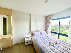 una camera da letto con un grande letto con una grande finestra di Dolce Lasalle a Bangkok