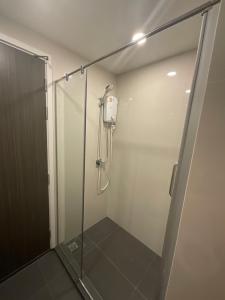 una doccia con porta in vetro in bagno di Dolce Lasalle a Bangkok