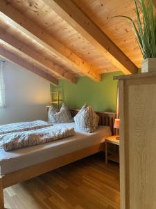 Bett in einem Zimmer mit Holzdecke in der Unterkunft Hotel Sonnenlicht Maria Alm in Maria Alm am Steinernen Meer