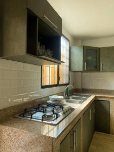 a kitchen with a stove and a sink at Pacific Suites Guayaquil Airport in Guayaquil
