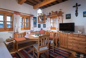 a dining room with a table and a tv at Traditional cozy cottage BOCANKA in Nižná Boca