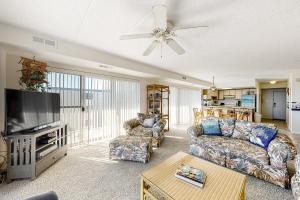 sala de estar con sofá y TV de pantalla plana en Blue Sea Colony 501, en Ocean City
