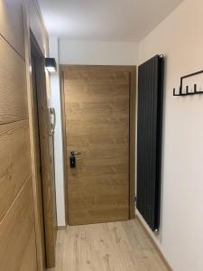a wooden door in a room with a hallway at Des Alpes C Flat 11 in Madonna di Campiglio