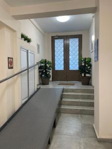 a hallway with stairs and a door with potted plants at G&M Luxury Studios in Thessaloniki
