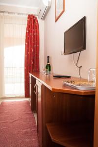 eine Küche mit einem Tisch, einem TV und einer Flasche Wein in der Unterkunft Korona Home in Sárvár