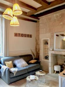 Vieux Tours, Charmant T2 40m2, 4 pers, lumineux في تور: غرفة معيشة مع أريكة زرقاء وطاولتين