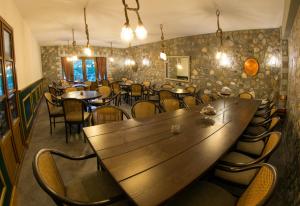 a restaurant with a large wooden table and chairs at Farma Sarli in Monódhrion