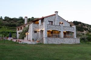 a large stone house in the middle of a field at Farma Sarli in Monódhrion