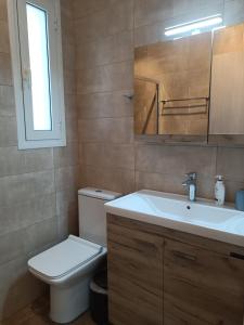 Łazienka z białą toaletą i umywalką w obiekcie Siggrou apartment w Atenach