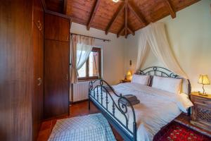 Livadi cozy villa في أراخوفا: غرفة نوم بسرير وسقف خشبي