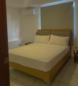 a bedroom with a bed with white sheets and pillows at Pacific Suites Guayaquil Airport in Guayaquil