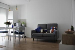 ein Wohnzimmer mit einem grauen Sofa und einem Tisch in der Unterkunft New apartment close to the Cinque Terre in La Spezia