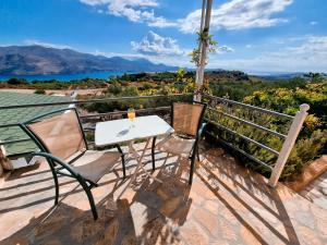 a table and chairs on the balcony of a house at Forestata Village in Lixouri